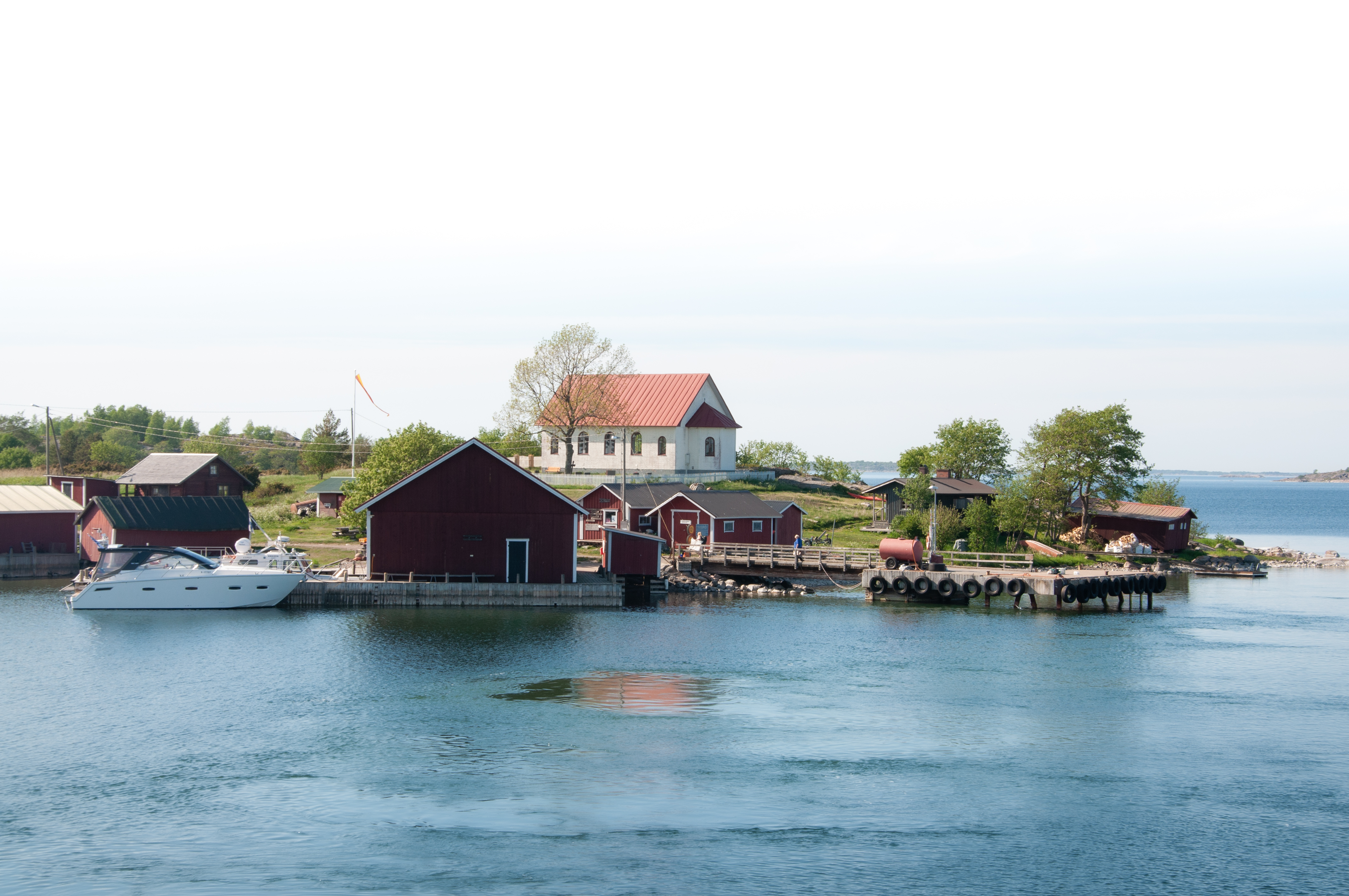 Bild tagen från havet över en ö där man ser en vit stenbyggnad, ett kapell.