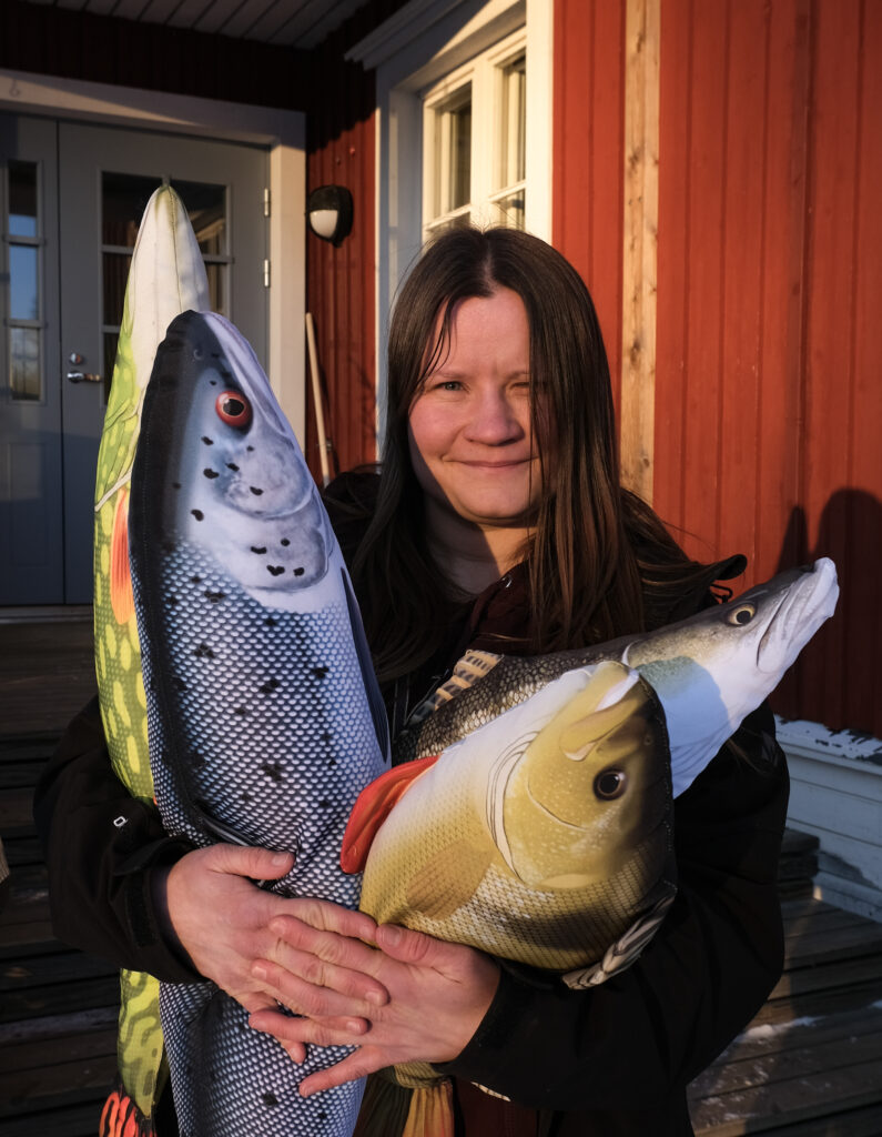 En glad kvinna med mjukisgäddor i famnen.