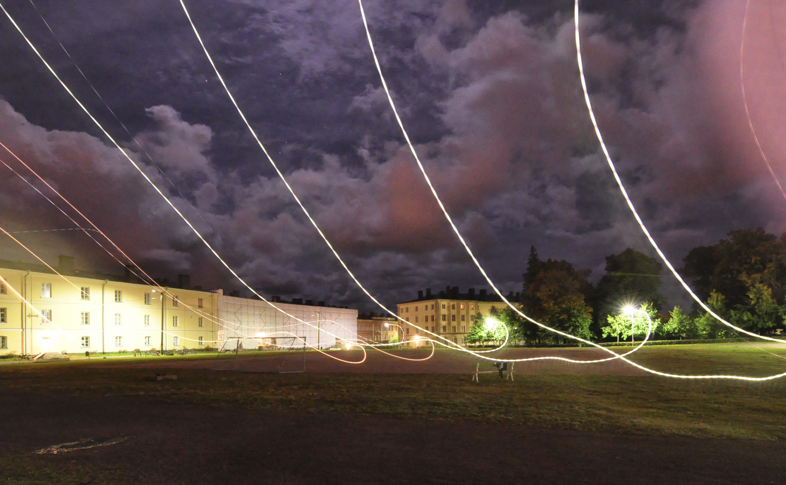 Tunga moln syns i mörkret ovanför en plan.