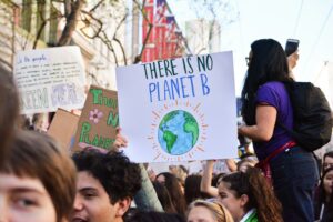 Barn som håller upp skylt med texten "There is no planet B."