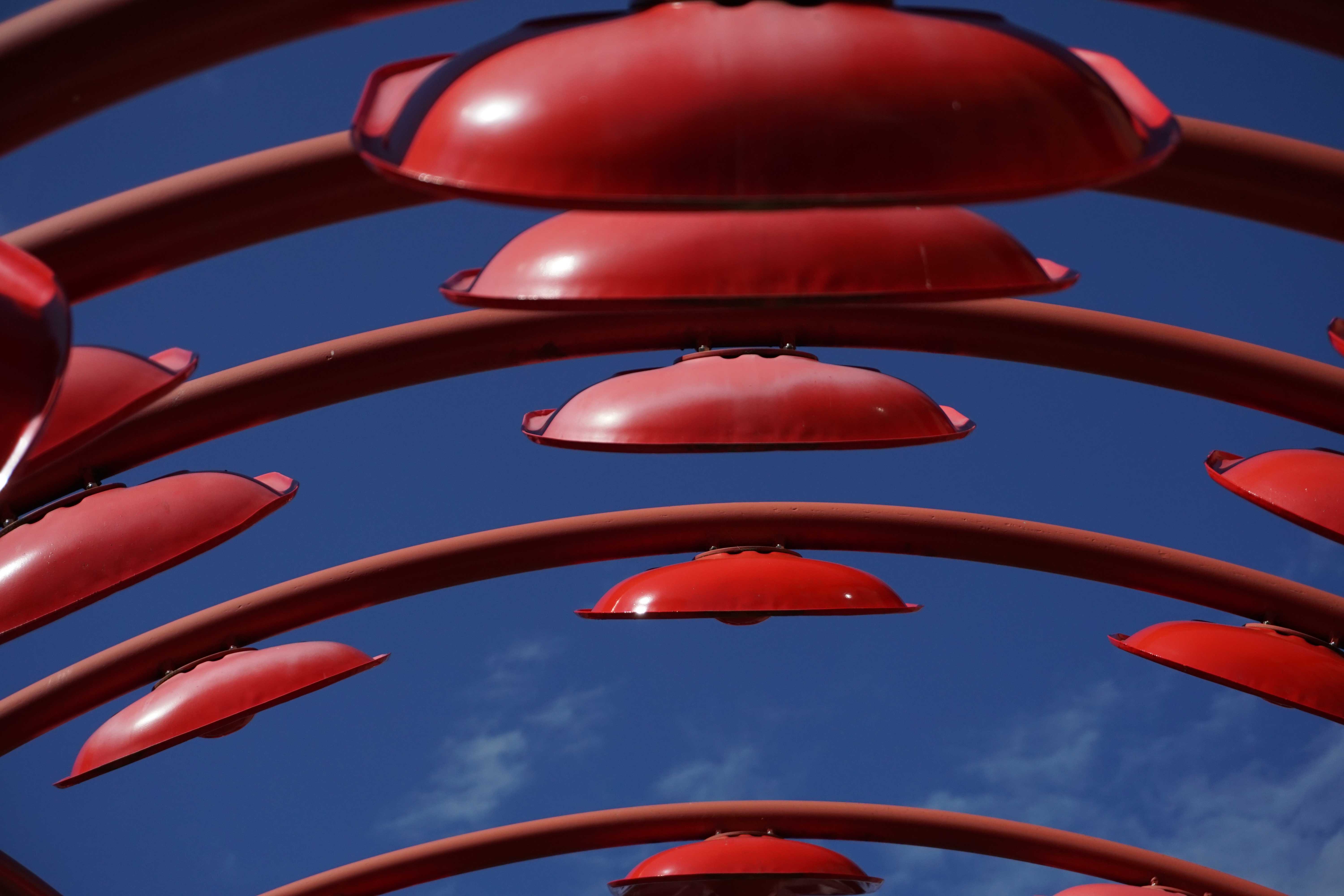 Dekorativ bild med röda föremål mot en blå himmel.