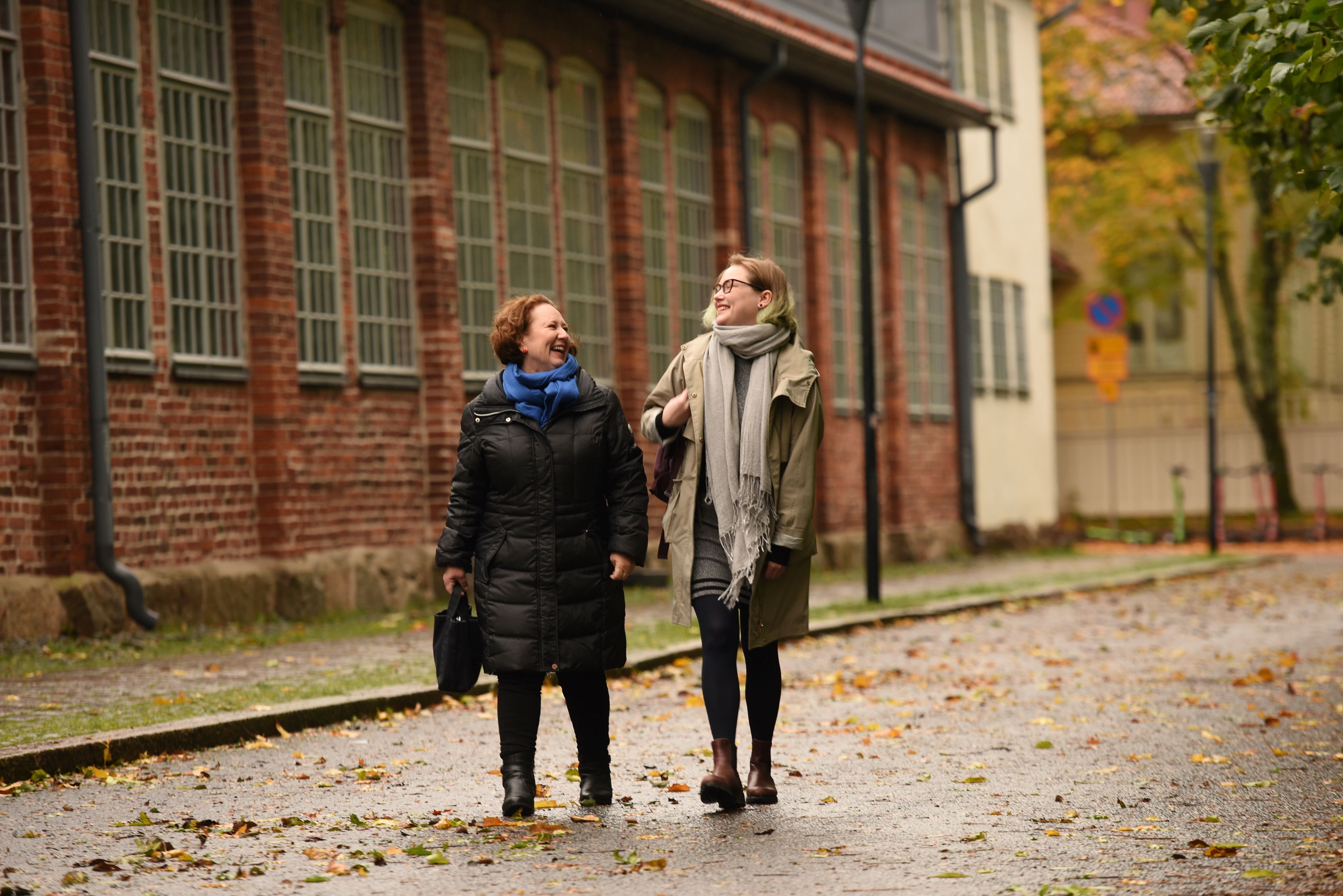 En äldre och en yngre kvinna går vid Auraån på hösten.
