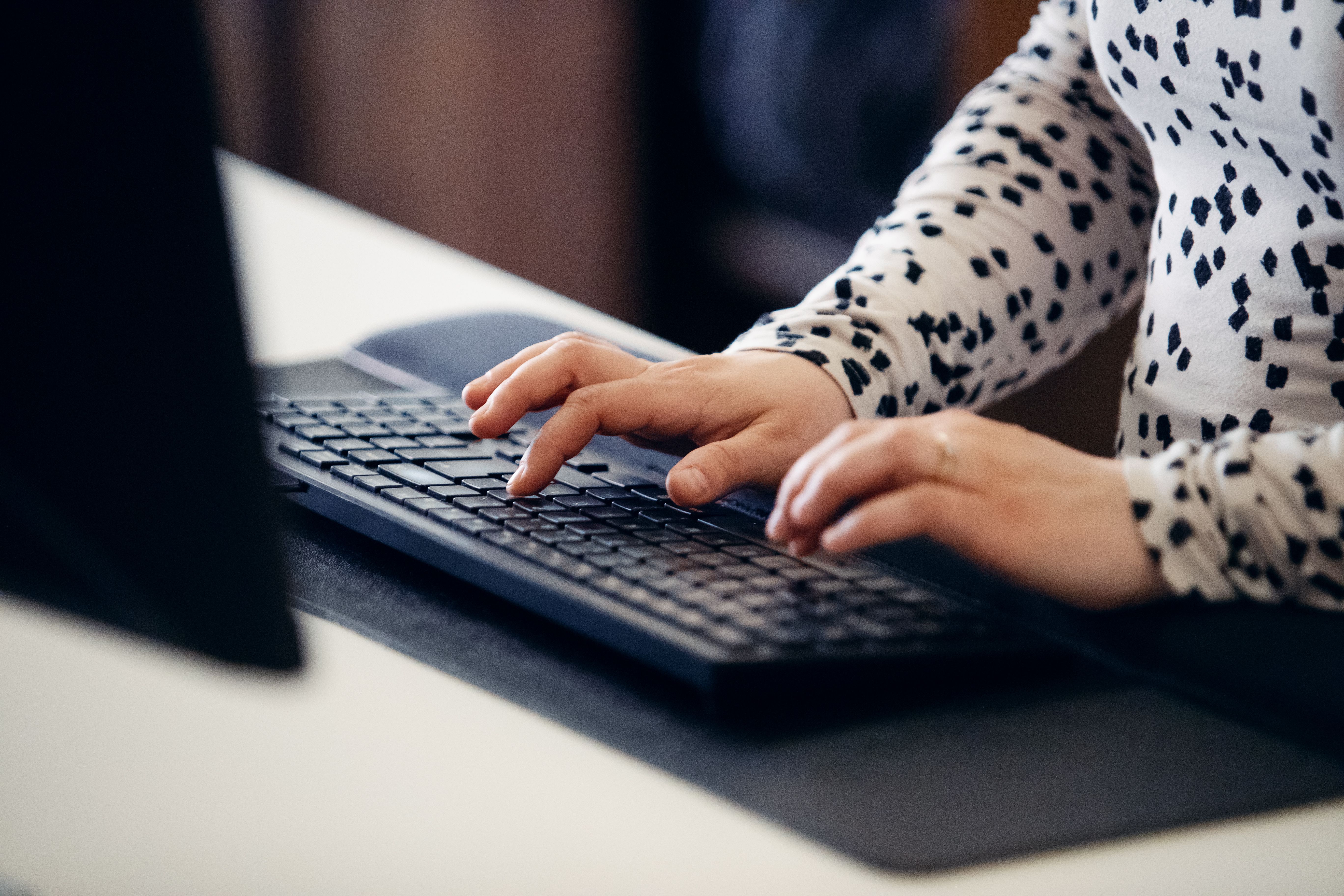 Närbild av kvinna som skriver på ett tangentbord