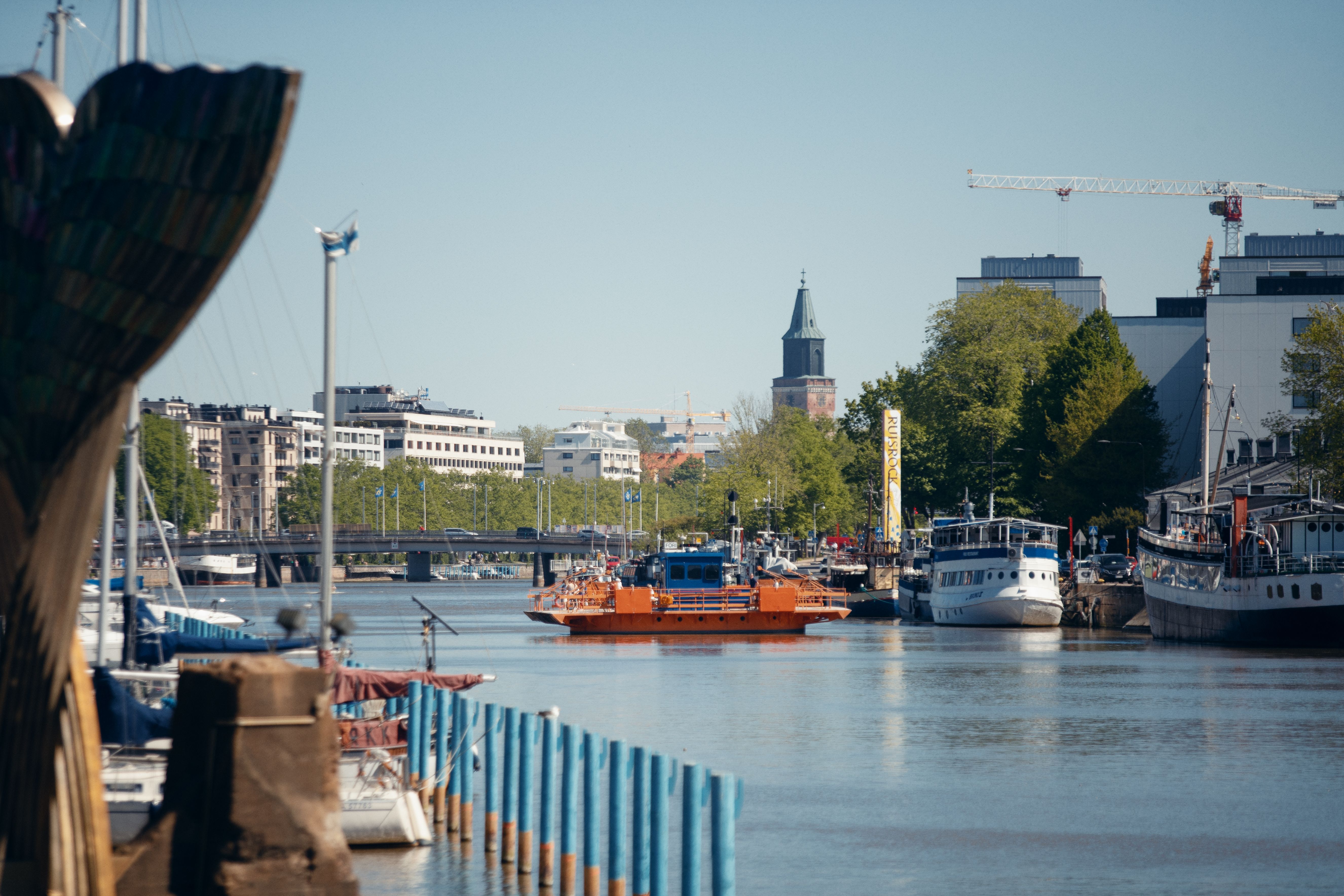 Landskap från Aura å, med båter, hus, och en blå himmel i bakgrunden