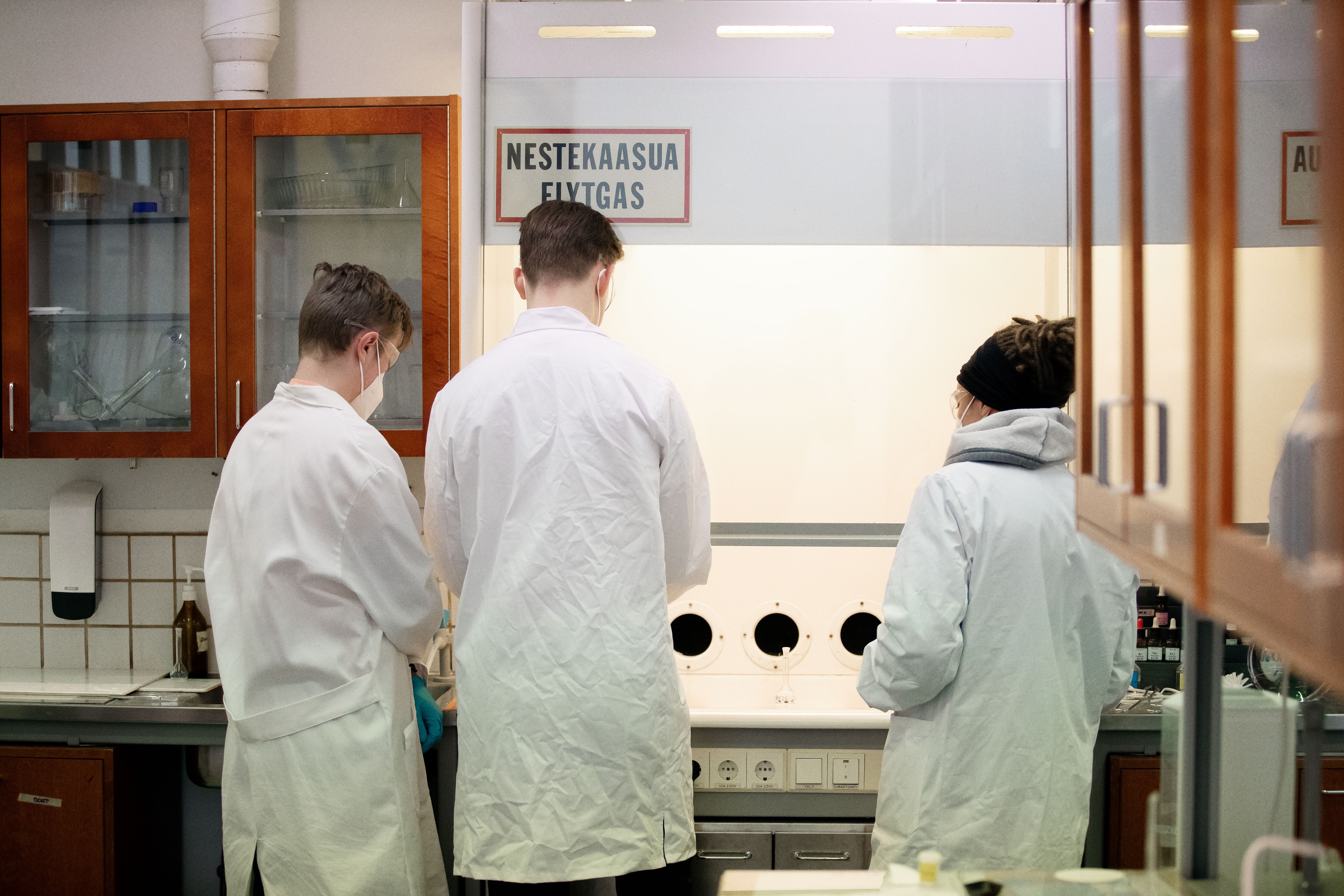 Tre personer i ett laboratorium.