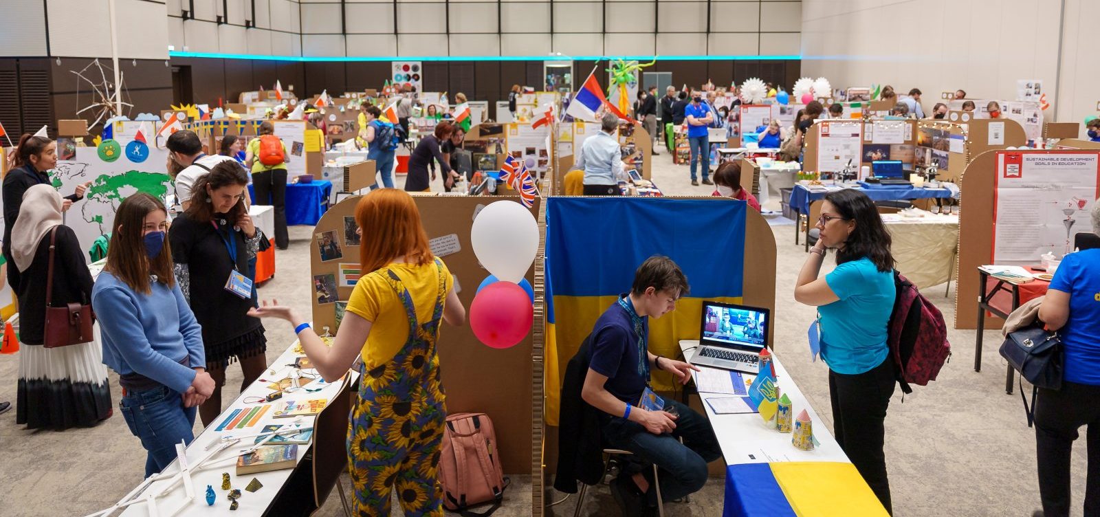 Mässa med färgglada utställningsbord.