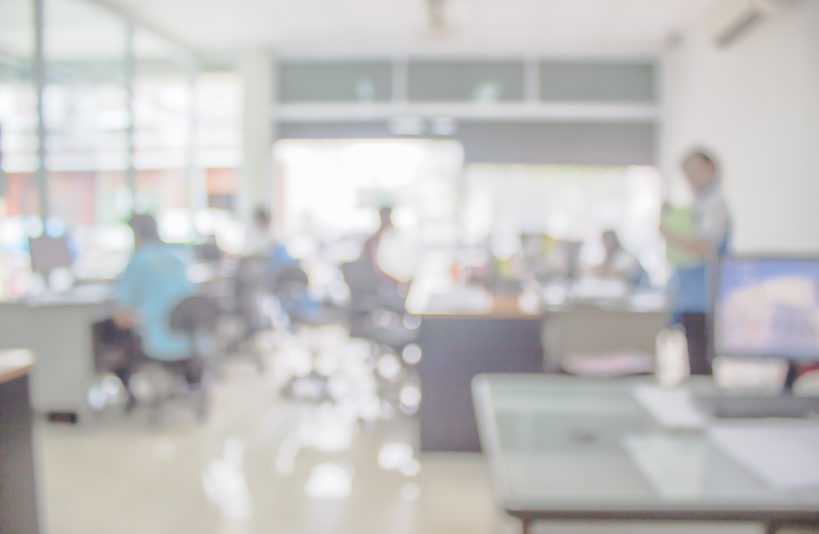 Businessmen blur in the workplace.Table Top And Blur Office of Background.abstract blur background table work in office with computer.Abstract background of office shallow depth of focus.