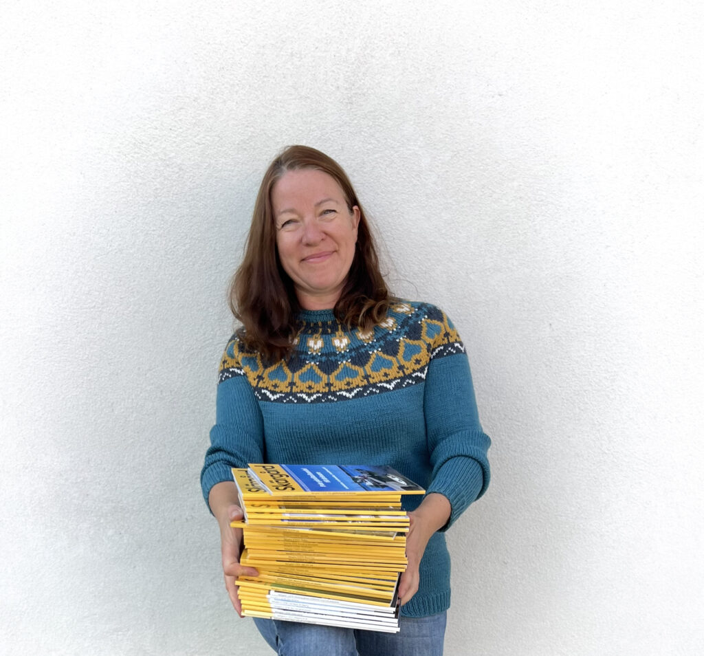 Pia Prost med en bunt Skärgård-tidskriften i famnen.